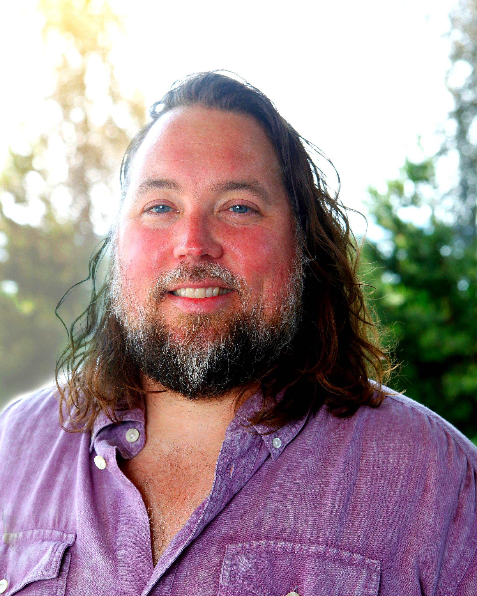 Sean Morrin in purple shirt standing outdoors in sunlight