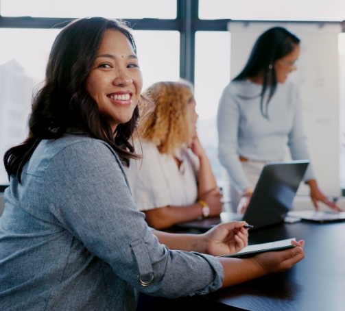 Smiling woman in a meeting with colleagues in an office